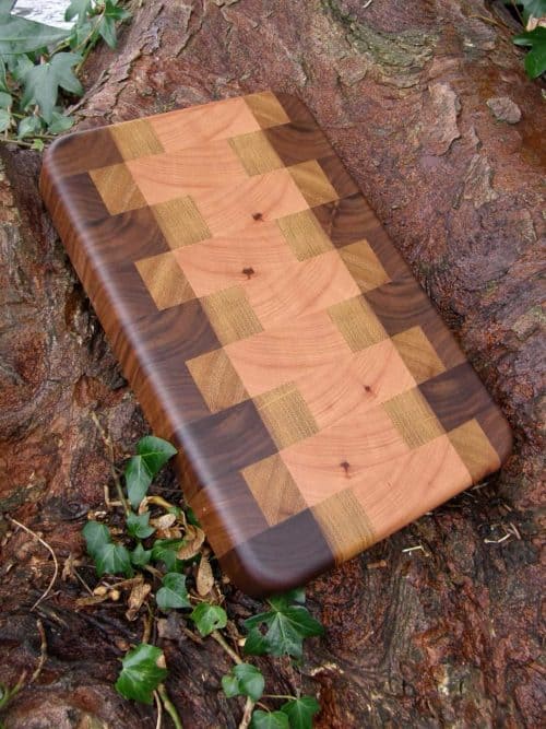 The Copper Point End Grain Chopping Board is Handmade in Walnut, Cherry & Iroko in a striking, unique pattern.