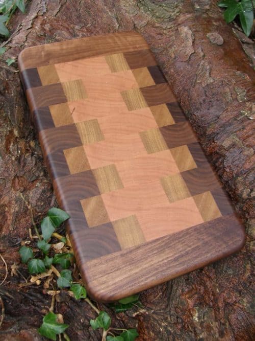 The Crookhaven End Grain Chopping Board is Handmade in Oak, Walnut, Iroko & Cherry with Long Grain Walnut edge. Crookhaven is fitted with recessed handles for easy lifting and finished with Antibacterial Worktop Oil.